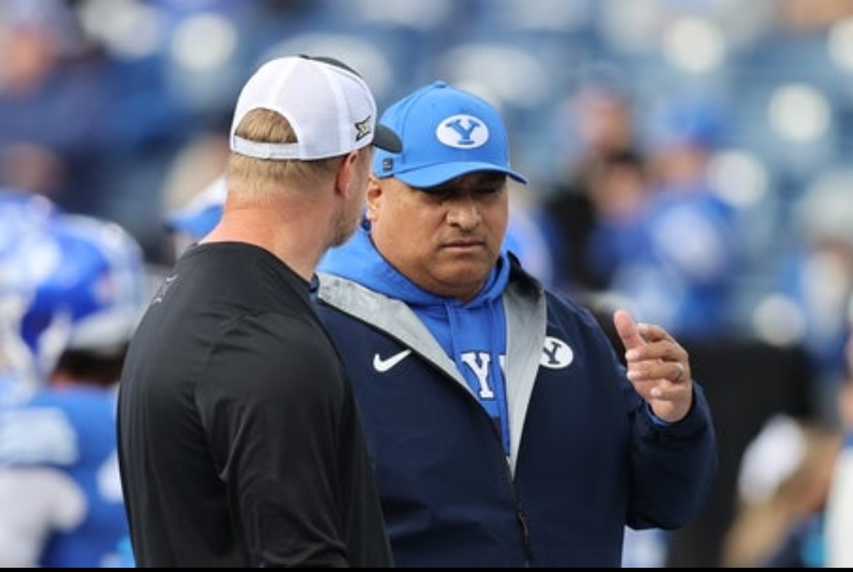 Nov 29, 2025; Provo, Utah, USA; BYU Cougars head coach Kalani Sitake, right, speaks with UCF Knights head coach Scott Frost before the game at LaVell Edwards Stadium. Mandatory Credit: Rob Gray-Imagn Images
